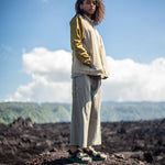 Woman standing on volcanic rock wearing Green Adventure Sandals