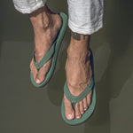 A man wearing leaf flip flops