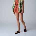 A woman standing wears Indosole black cross sandals