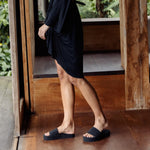 Woman wearing black platform slides with black dress