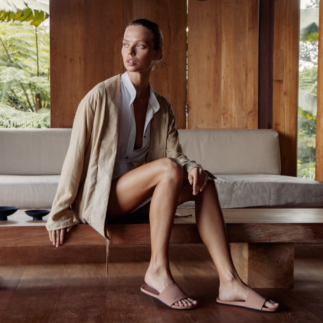 Woman wearing house slippers in light red/rust