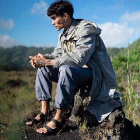 Man sitting on rock in outdoors wearing black adventure sandals Hijack 