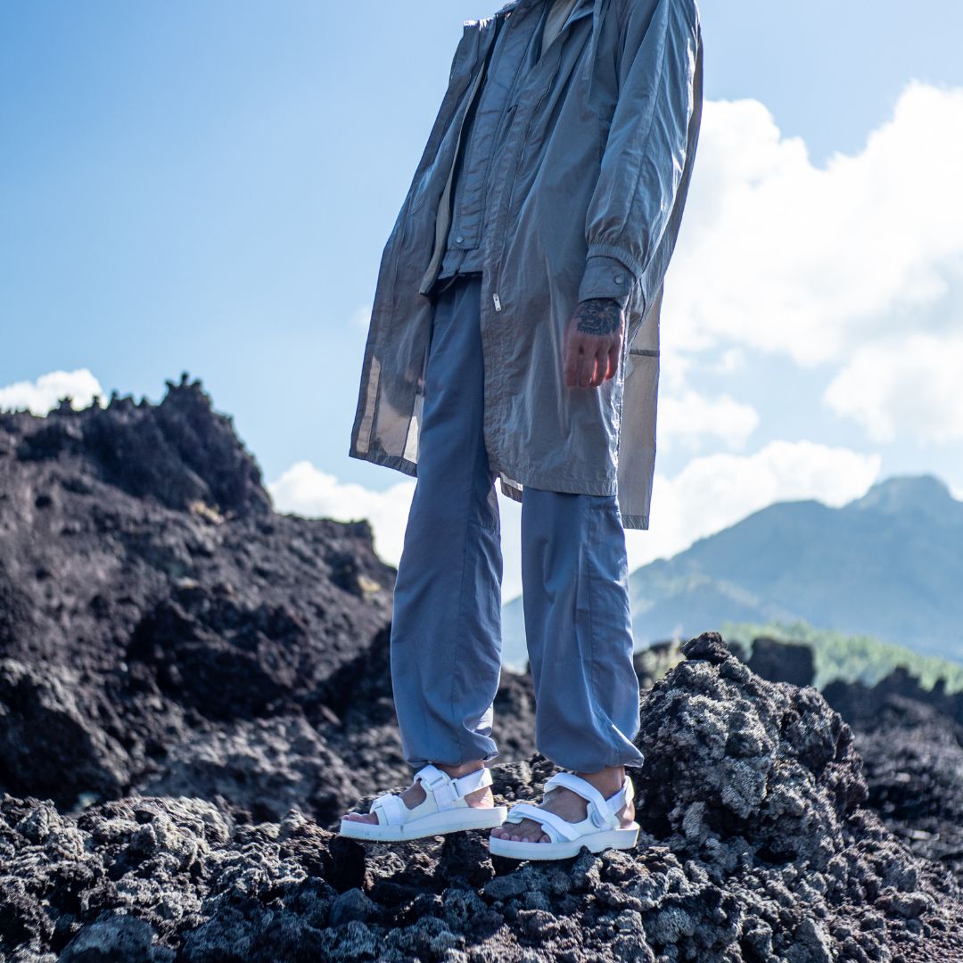 Man standing on mountain wearing Indosole Hi Jack white Adventure Sandals in White on Gravel