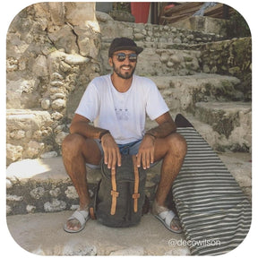A man sitting wearing light soil cross sandals