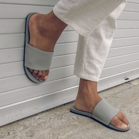Man wearing granite slides with one foot on the ground and the other against the wall (2385873600589)