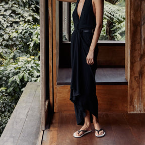 Woman wearing black loungewear dress with white and black slippers flip flops